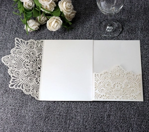 Detail of laser-cut mandala floral pattern on champagne pearlescent wedding invitation