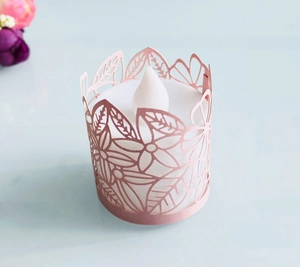 Dettaglio del paralume in carta traforata rosa chiaro con una candela LED a luce bianca