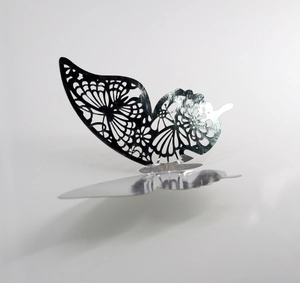 Detailed macro shot of silver hollow 3D butterfly wall sticker with laser-cut wing patterns