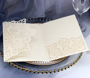 Close-up of laser-cut mandala patterns on champagne-colored wedding invitation card