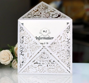 Detail showing the laser-cut floral patterns on elegant white wedding invitation card