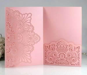 Detail of pink laser-cut lace wedding invitation with intricate mandala floral pattern