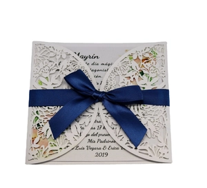 Elegant laser-cut floral wedding invitation with navy blue ribbon and butterfly detail