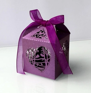 Detail of laser-cut heart and bird pattern on purple pearlescent wedding candy box