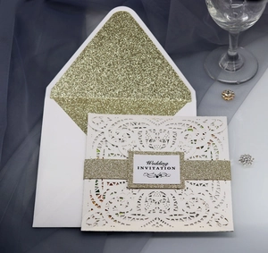 Detail of laser-cut wedding invitation with gold glitter band and shimmering inner envelope