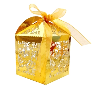 Golden laser-cut wedding favor box with floral patterns and a matching ribbon bow