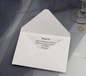 Macro detail of elegant laser-cut white Quinceañera invitation cards with leaf patterns