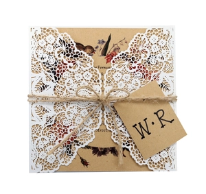 Detail of laser-cut lace wedding invitation with vintage kraft paper and jute twine bow