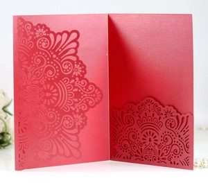 Macro shot of red laser-cut invitation card with intricate mandala floral patterns