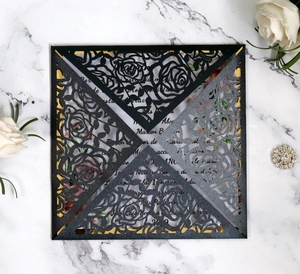 Intricate laser-cut rose design on black pearl paper wedding invitation set