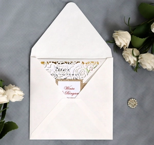 Laser-cut white rose wedding invitation with elegant hollow patterns and matching envelope
