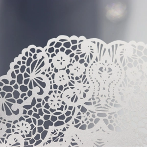 Elegant laser-cut white lace wedding invitation with intricate floral and butterfly details