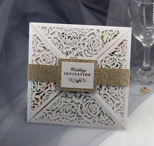 Detail of laser-cut rose floral wedding invitation with gold glitter band and white card