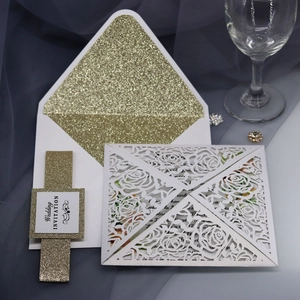 Close-up of laser-cut rose hollow invitation with gold glitter liner and wedding tag