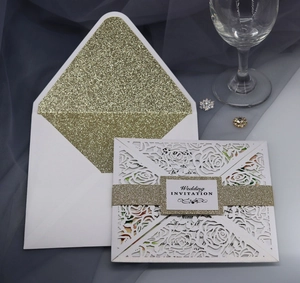 Detail of laser-cut rose hollow wedding invitation with gold glitter belly band