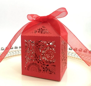 Elegant red laser-cut hollow candy gift box featuring floral patterns and a red chiffon ribbon