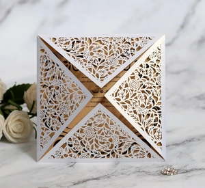 Détail de l'invitation découpée au laser blanche avec carte dorée sur marbre