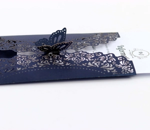 Macro view of navy blue laser cut wedding invitation with 3D butterfly detail