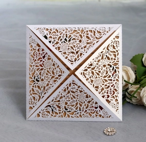 Détail de motifs floraux découpés au laser sur cartes d'invitation blanc nacré