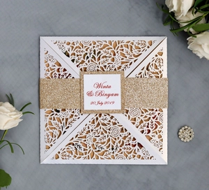 Détail du faire-part de mariage découpé au laser avec bande pailletée dorée chic