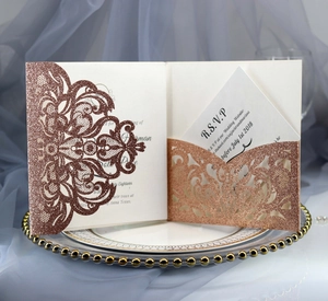 Detail of rose gold laser-cut wedding invitation with glitter finish and RSVP card