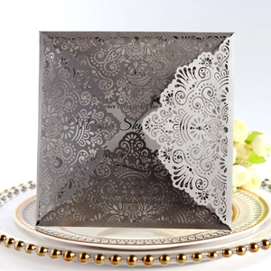 Elegant laser-cut silver lace wedding invitation with intricate floral hollow patterns