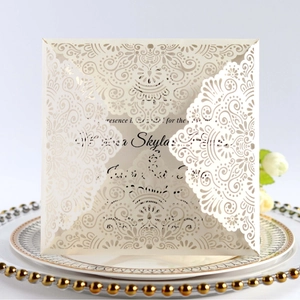 Elegant laser cut wedding invitation card with intricate ivory lace and gold plate decor