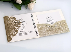 Detail view of gold glitter laser-cut wedding invitation cards with ivory RSVP set