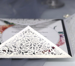 Vue macro détaillée du motif floral découpé au laser sur papier blanc nacré élégant
