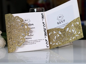 Detail of glitter gold laser cut wedding invitation with elegant baroque floral patterns