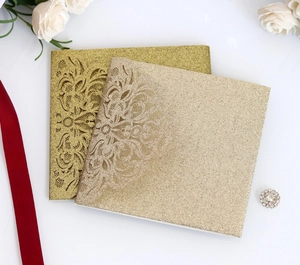 Detail of laser-cut glitter wedding invitation with elegant hollow floral pattern
