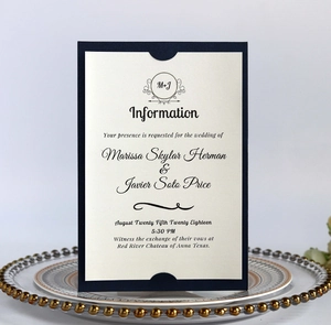 Detail of navy blue wedding invitation with ivory card on a gold beaded glass plate