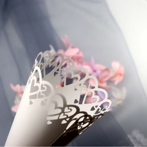 White laser cut paper cones with heart lace patterns for elegant wedding petal confetti