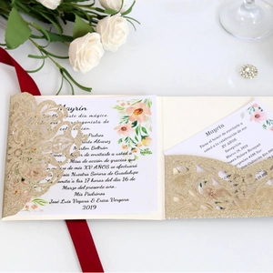 Elegant gold laser cut wedding invitation with floral inner card and red ribbon detail