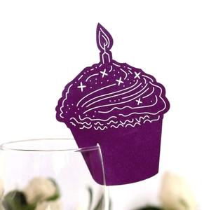Detail of purple cupcake-shaped place cards with candle patterns for glass rim decor
