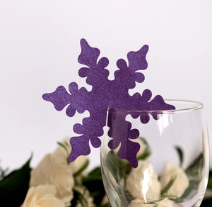 Macro shot of purple glitter snowflake place card laser cut on clear glass rim
