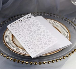 Close-up of elegant laser-cut floral wedding invitation card on decorative plate