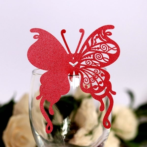 Elegant red glitter butterfly place card with laser cut design on a glass rim