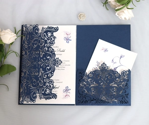 Detailed close-up of navy laser-cut wedding invitation with delicate hollow floral patterns