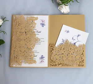 Close-up of laser-cut gold wedding invitation featuring intricate European floral patterns