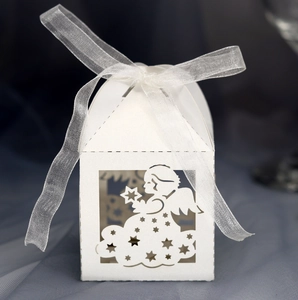 Close-up of laser-cut white paper candy box with angel pattern and white ribbon