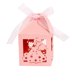 Detail of pink laser-cut candy box featuring angel pattern and sheer organza ribbon