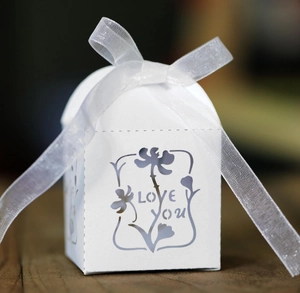 Laser-cut white wedding candy box featuring LOVE YOU floral design and white ribbon bow