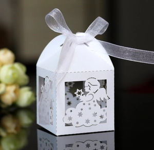 Detail view of laser-cut angel candy box with white paper texture and silver ribbon bow