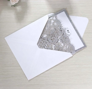 Detail of silver glitter laser cut floral wedding invitation card with white envelope