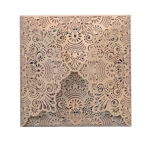 Detail of champagne gold laser cut invitation featuring intricate mandala cutout patterns