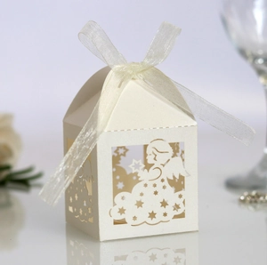 Detail of laser-cut angel candy box with hollow design and white organza ribbon bow