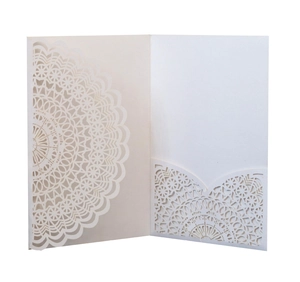 Detail of laser-cut lace pattern on cream invitation card with functional pocket slot