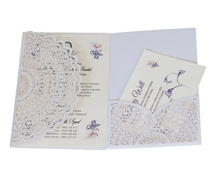 Intricate laser-cut white wedding invitation set with elegant floral inner card