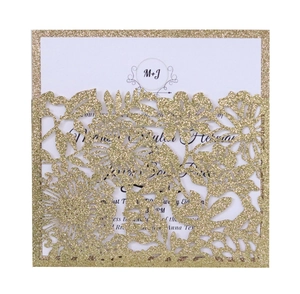 Detail of laser-cut floral wedding invitation pocket in gold glitter finish with white insert